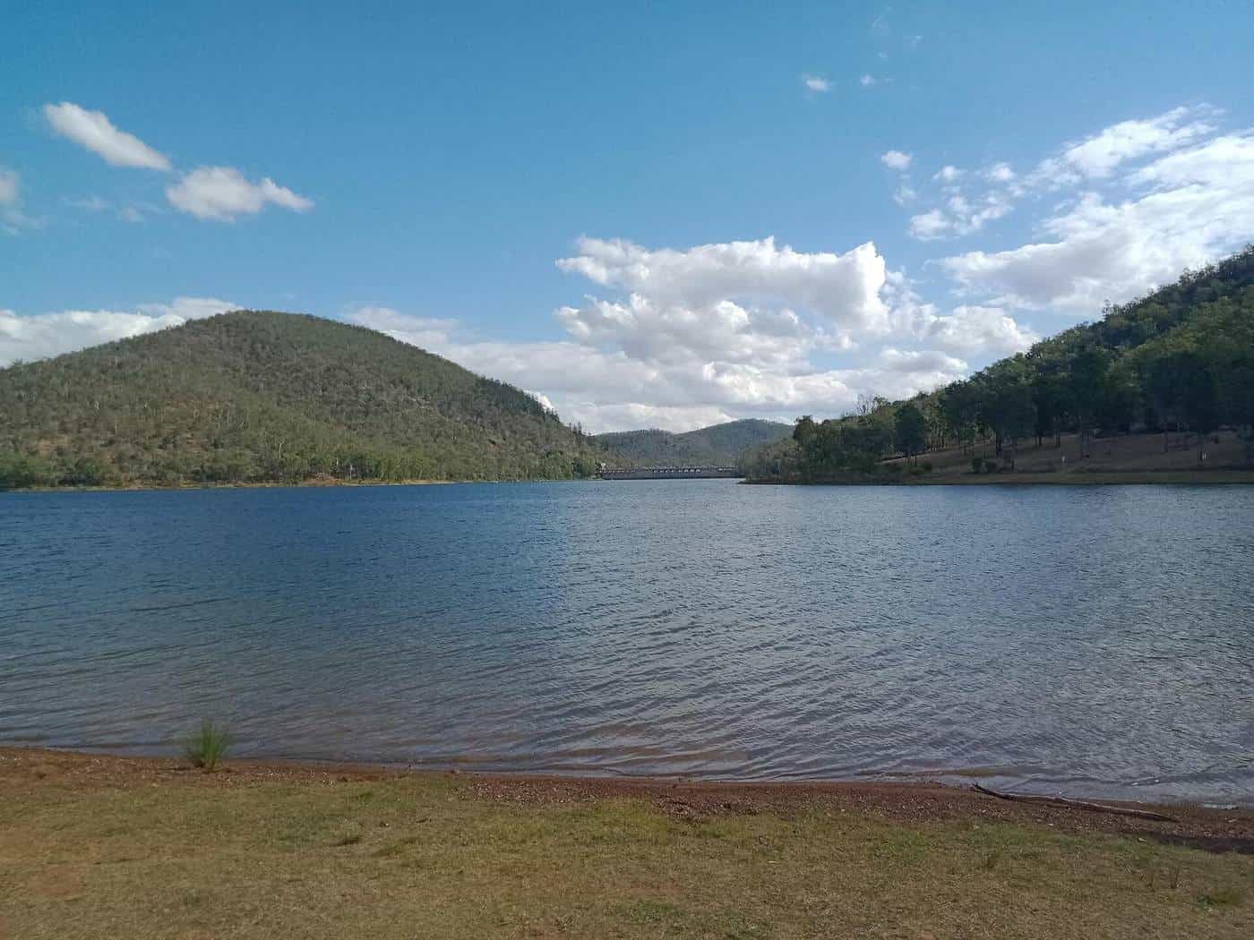 Lake Somerset's broad blue water with forested hills and a bright, cloudy sky